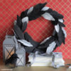 Crepe paper black feather wreath crafted from the Lia Griffith Botanical Garden paper pack, featuring realistic green leaves.
