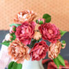 Close up frosted paper camellia flower arrangement in vase