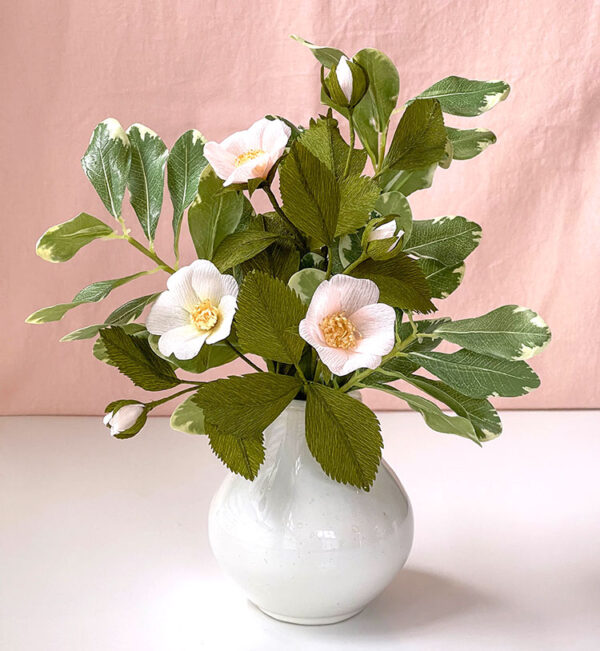 Crepe paper wild roses display inside white vase