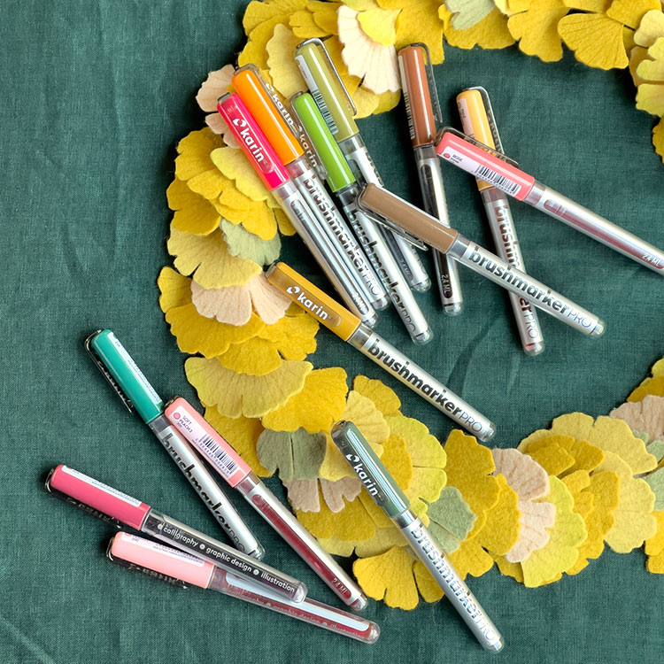 Markers sitting on a wreath of yellow felt flowers.